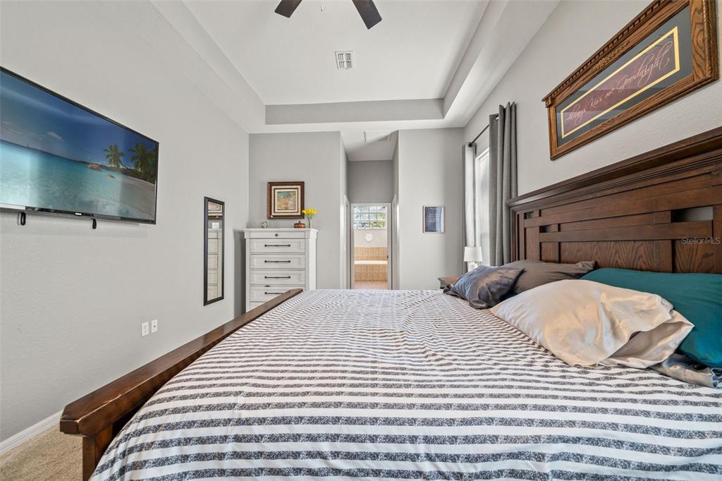 11180 Flock Avenue Weeki Wachee, FL 34613 - Photo 34 of 83 a bedroom with a bed and a flat screen tv