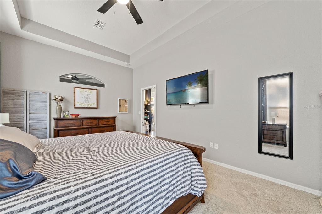 11180 Flock Avenue Weeki Wachee, FL 34613 - Photo 36 of 83 a bedroom with a large bed and a flat tv screen on a dresser