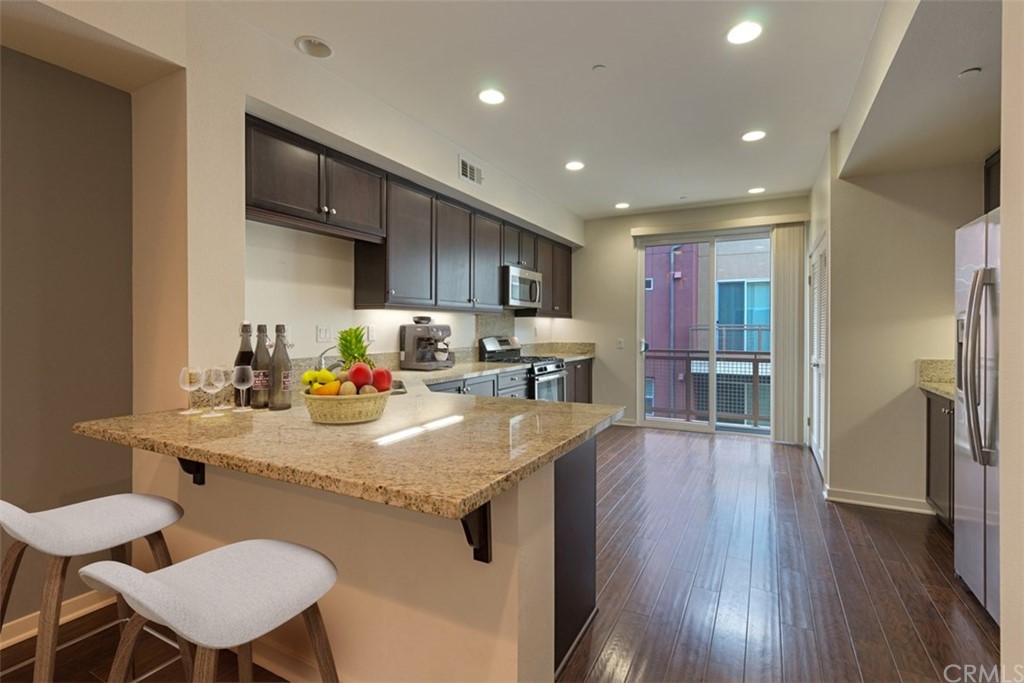 53 Waldorf Irvine, CA 92612 - Photo 2 of 28 a kitchen with stainless steel appliances granite countertop a sink refrigerator and cabinets