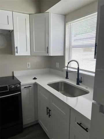 a kitchen with granite countertop a sink and a stove