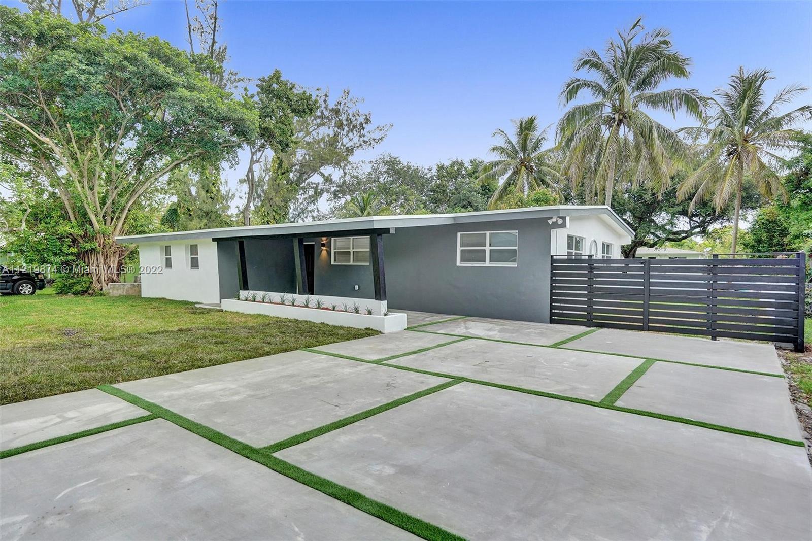 front view of a house with a yard and potted plants