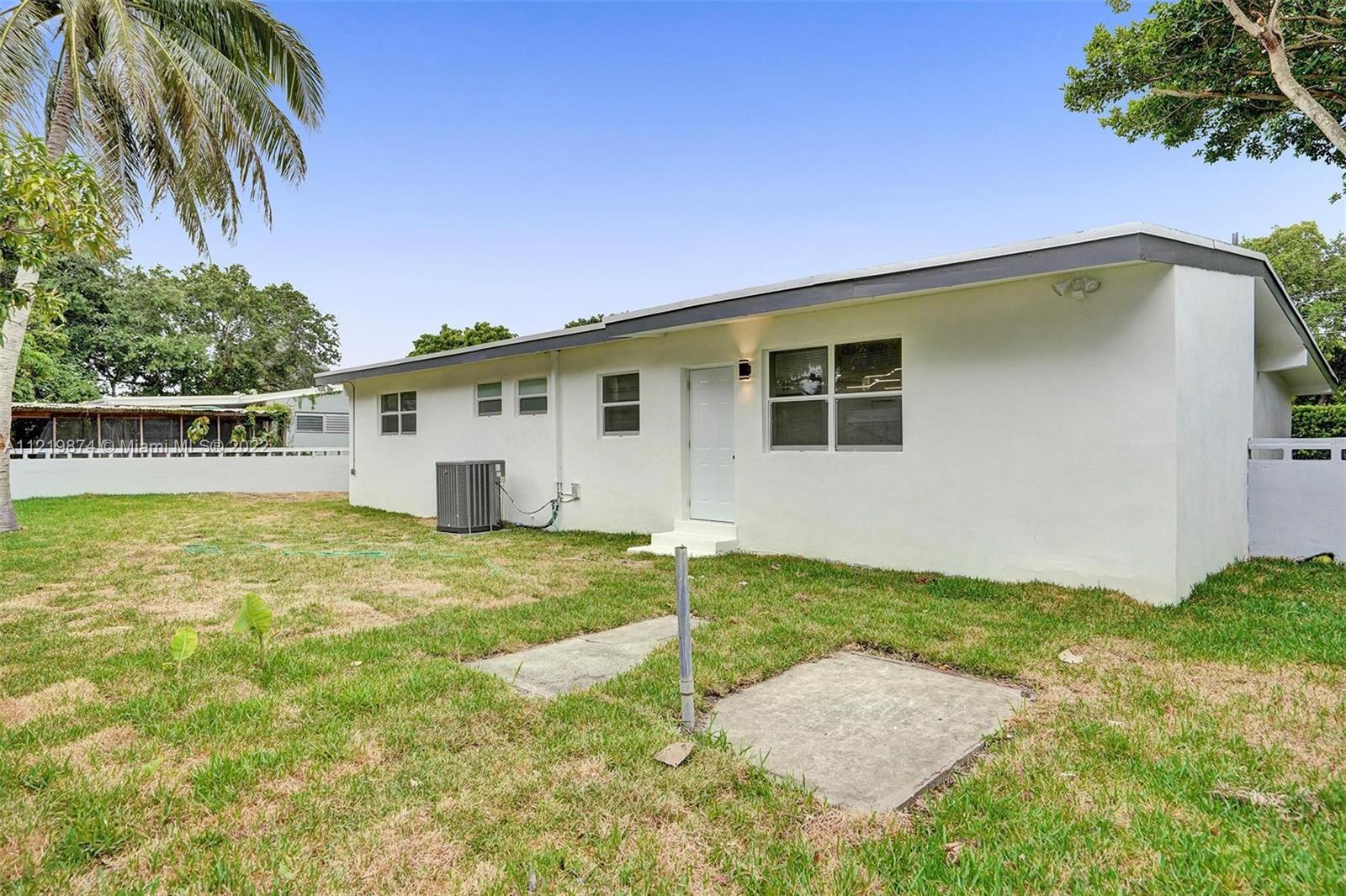 369 Northeast 158th Street Miami, FL 33162 - Photo 15 of 58 a backyard of a house with table and chairs