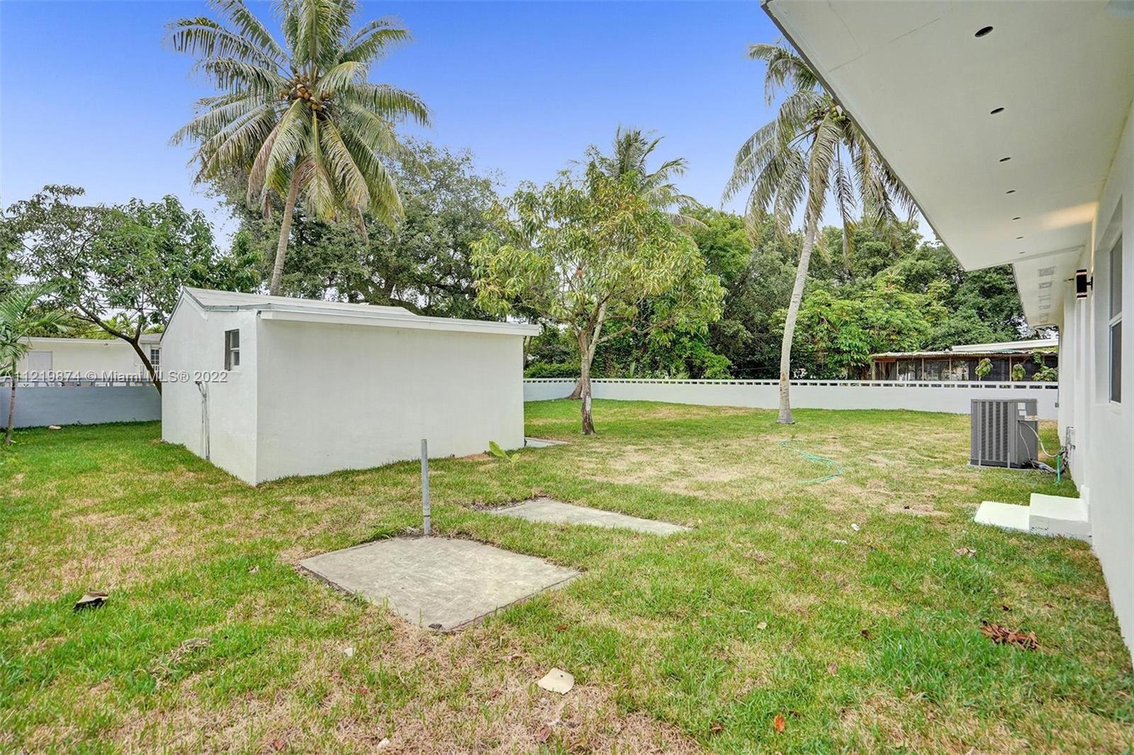 369 Northeast 158th Street Miami, FL 33162 - Photo 16 of 58 a backyard of a house with palm trees