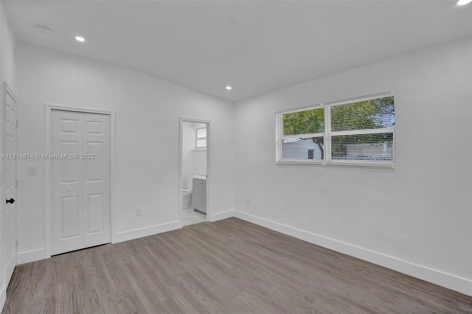 369 Northeast 158th Street Miami, FL 33162 - Photo 20 of 58 a view of an empty room with wooden floor and a window