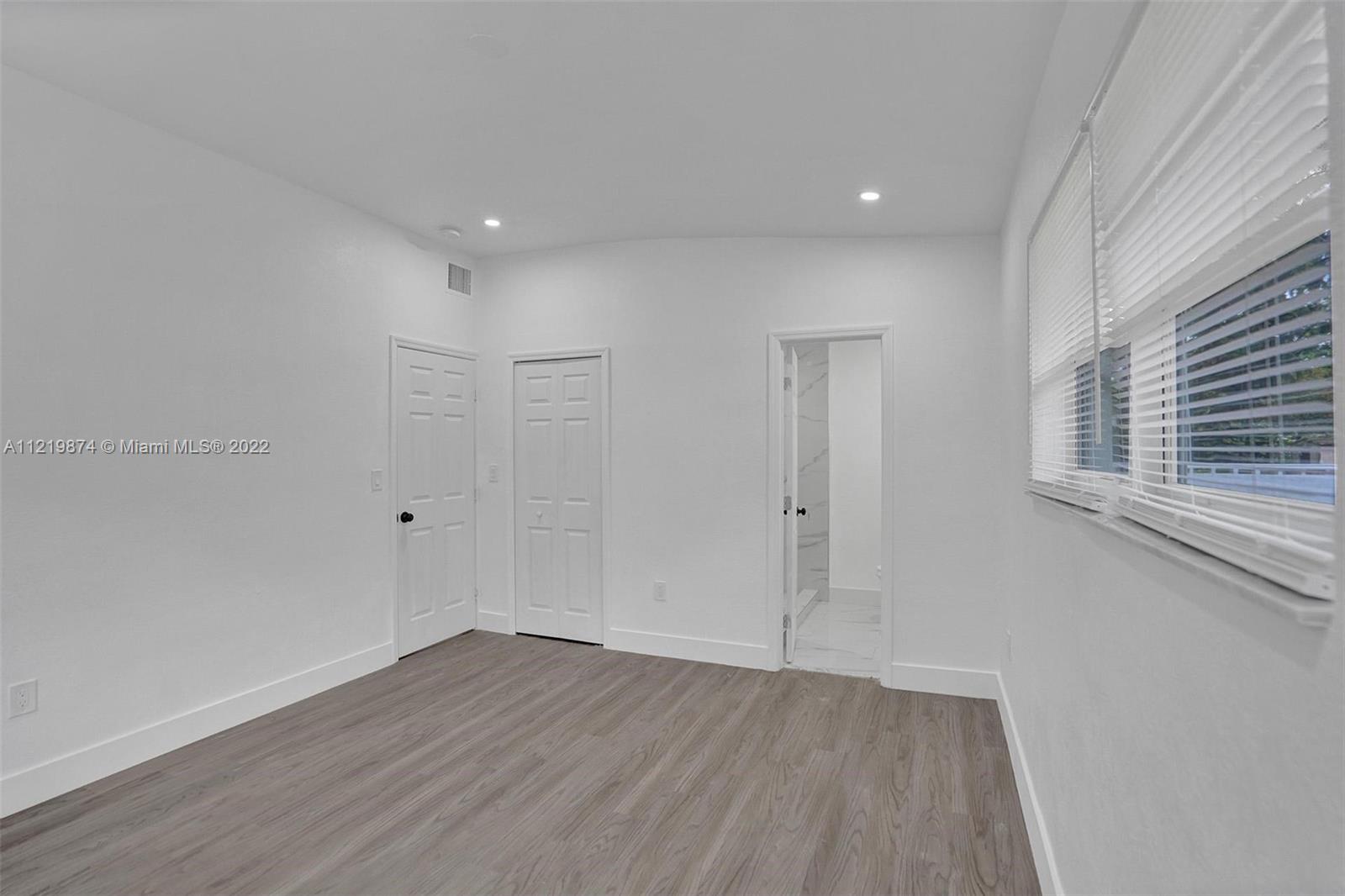 369 Northeast 158th Street Miami, FL 33162 - Photo 21 of 58 a view of a room with wooden floor and window