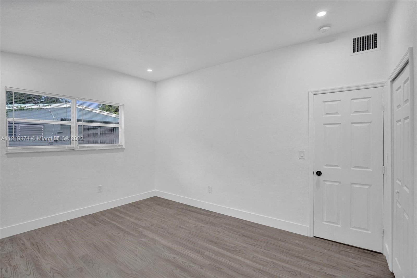 369 Northeast 158th Street Miami, FL 33162 - Photo 22 of 58 a room with wooden floor and white walls
