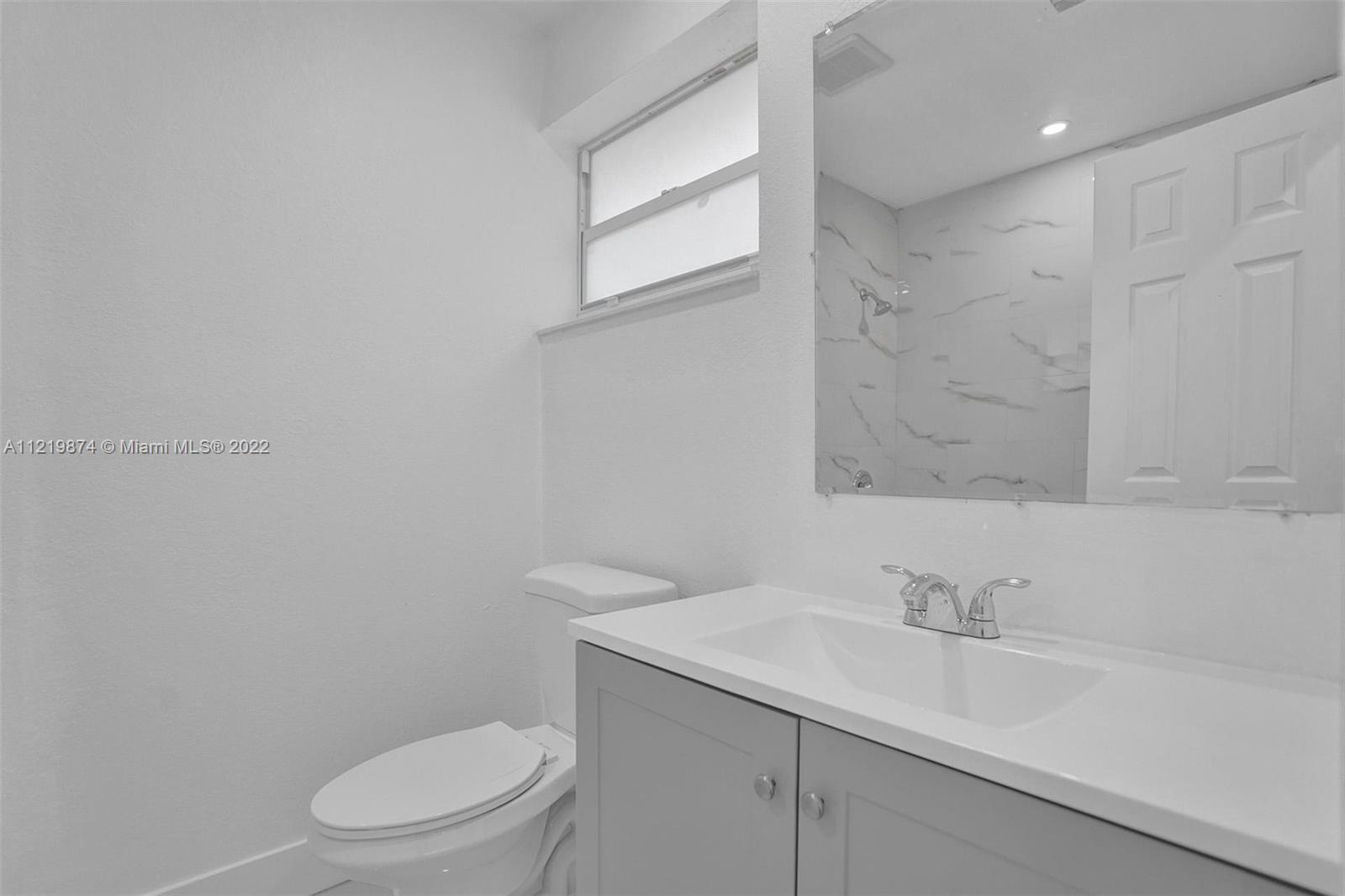 369 Northeast 158th Street Miami, FL 33162 - Photo 23 of 58 a bathroom with a sink a toilet and a mirror