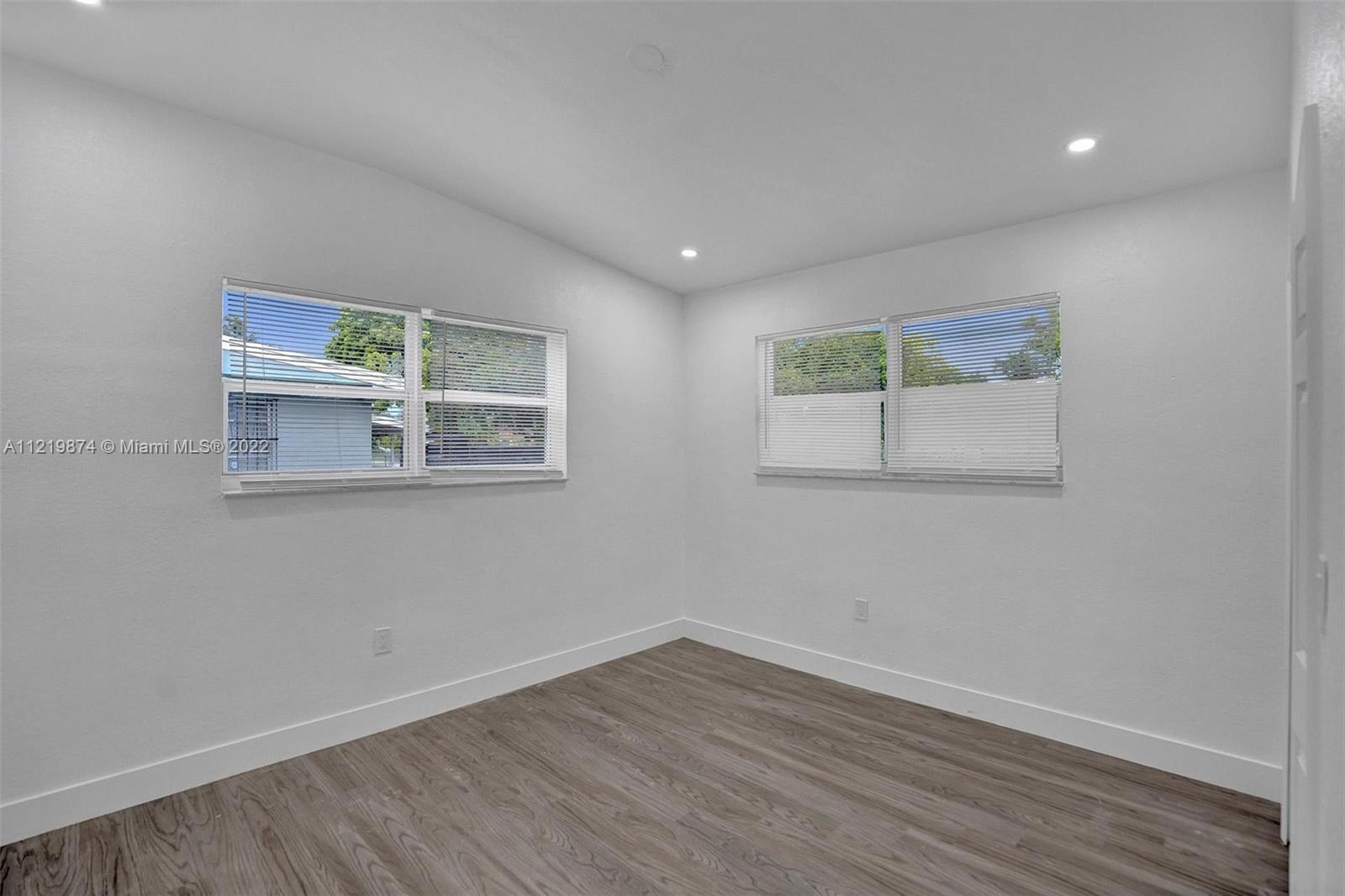 369 Northeast 158th Street Miami, FL 33162 - Photo 27 of 58 a view of an empty room with wooden floor and a window