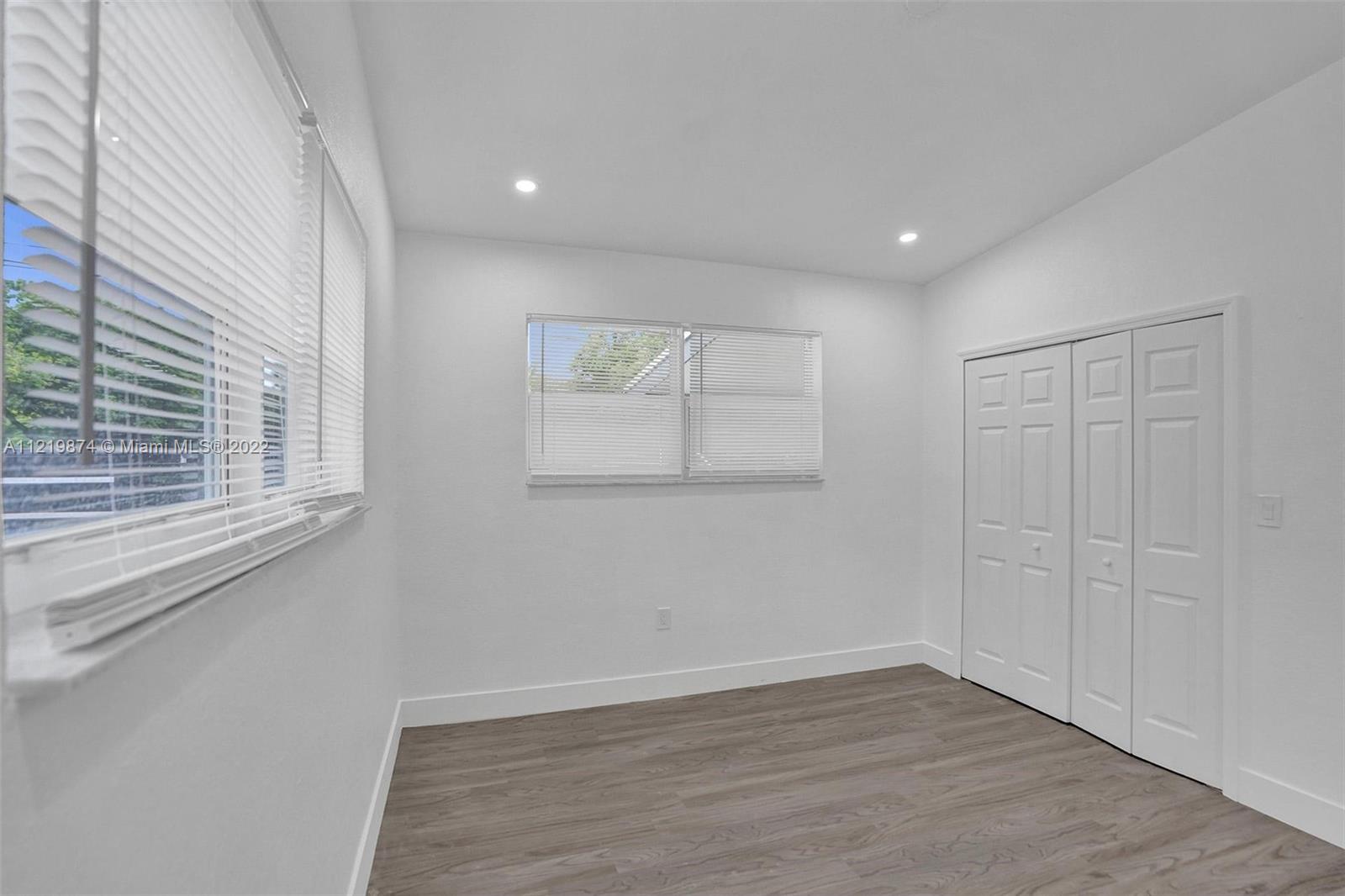 369 Northeast 158th Street Miami, FL 33162 - Photo 28 of 58 wooden floor in an empty room with a window