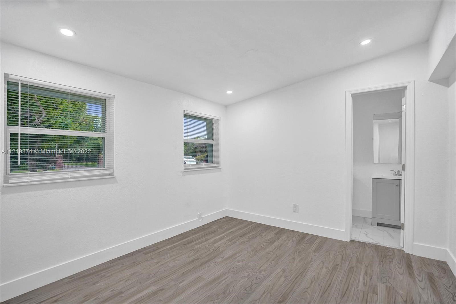 369 Northeast 158th Street Miami, FL 33162 - Photo 41 of 58 a view of an empty room with wooden floor and a window