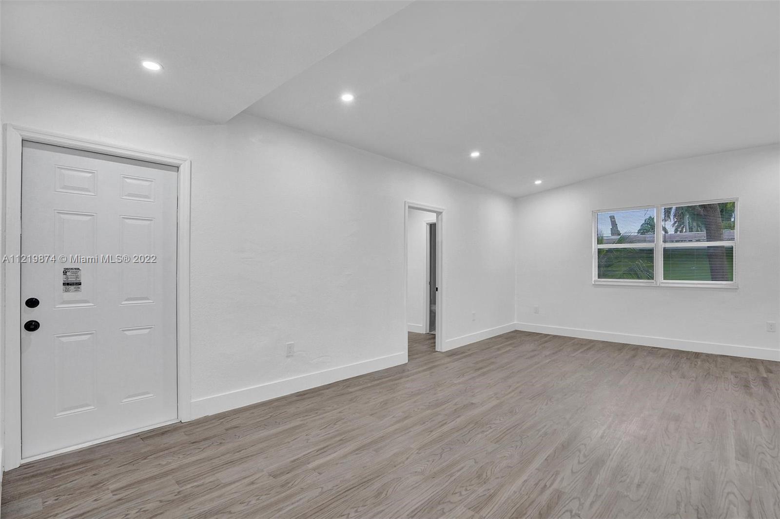 369 Northeast 158th Street Miami, FL 33162 - Photo 49 of 58 an empty room with wooden floor and windows