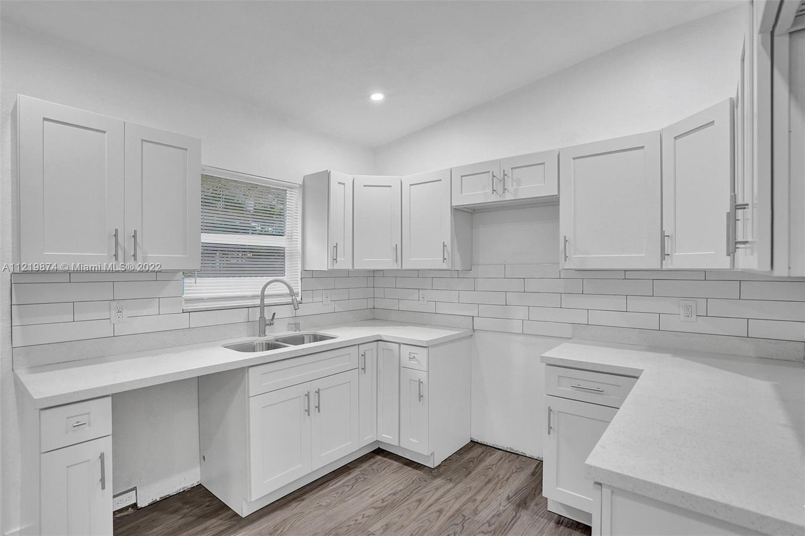 369 Northeast 158th Street Miami, FL 33162 - Photo 52 of 58 a kitchen with a sink dishwasher and cabinets
