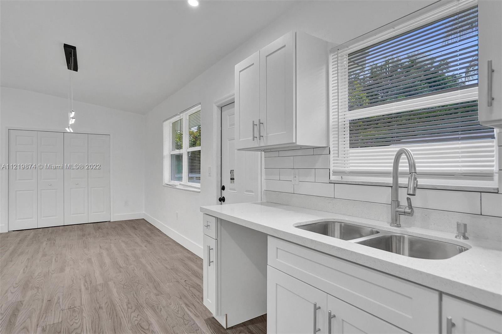 369 Northeast 158th Street Miami, FL 33162 - Photo 54 of 58 a kitchen with a sink and cabinets