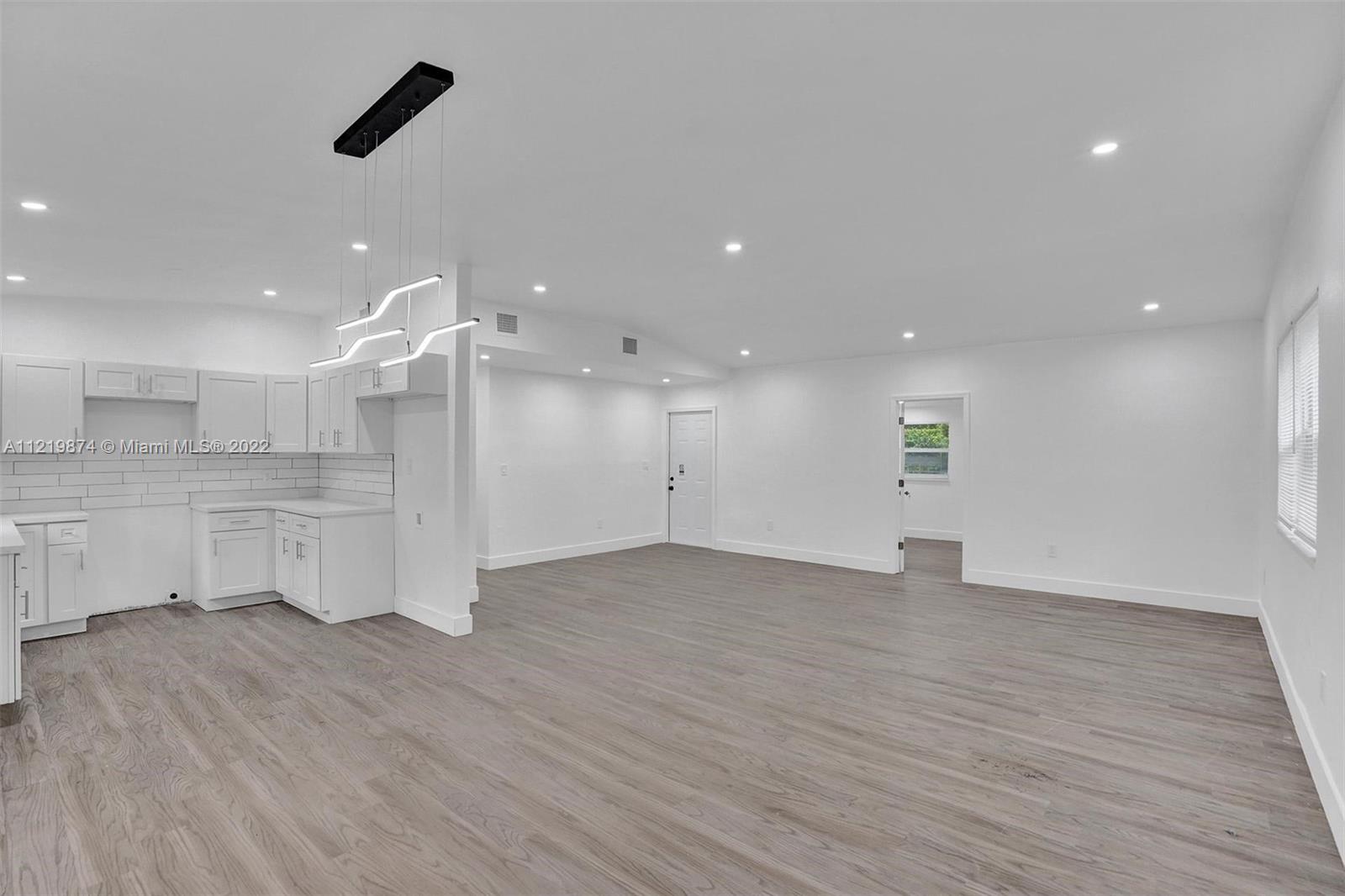 369 Northeast 158th Street Miami, FL 33162 - Photo 57 of 58 a view of an empty room with wooden floor and a window