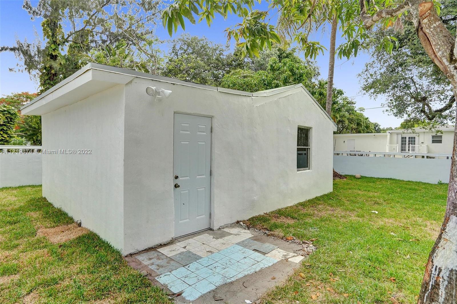 369 Northeast 158th Street Miami, FL 33162 - Photo 10 of 58 a backyard of a house with plants and tree