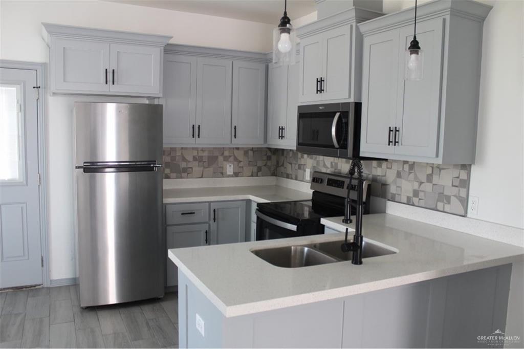 5609 Ozark Avenue, Unit 1 Mission, TX 78573 - Photo 3 of 8 a kitchen with a refrigerator and a sink