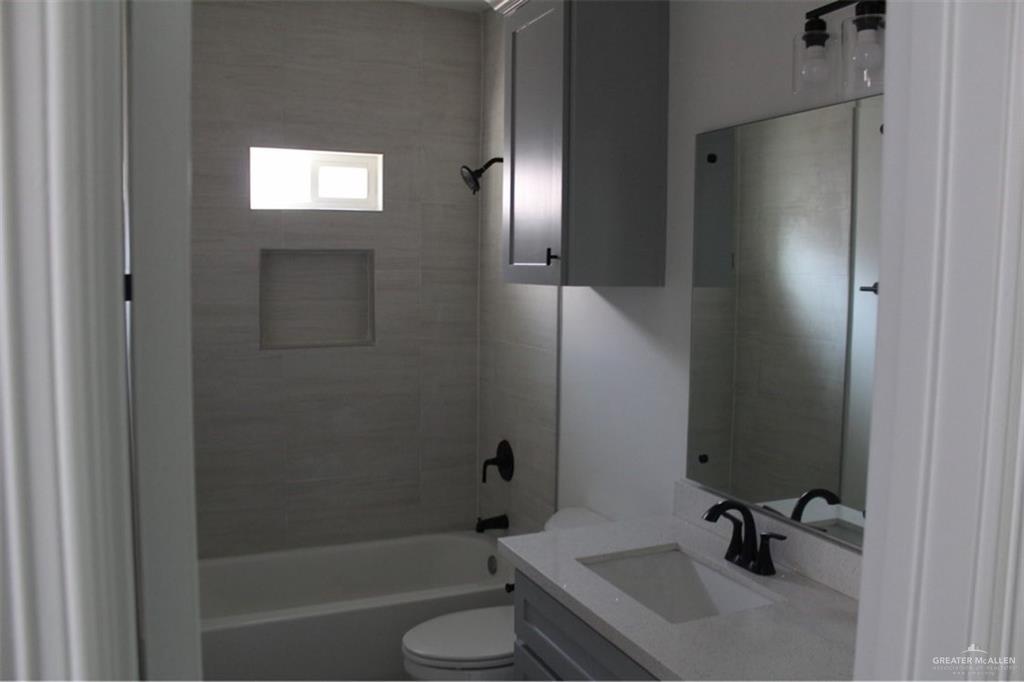 5609 Ozark Avenue, Unit 1 Mission, TX 78573 - Photo 6 of 8 a bathroom with a sink a toilet and shower