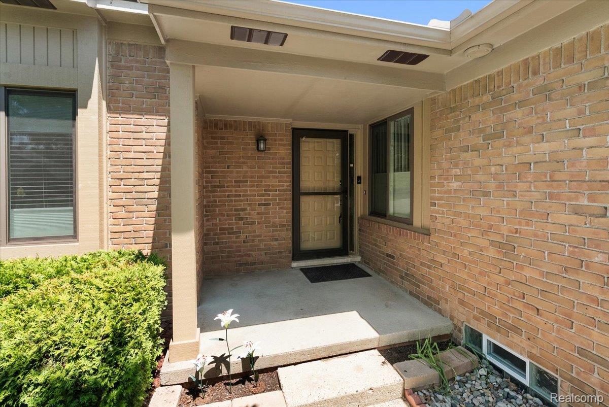 552 Tennyson Rochester, MI 48307 - Photo 4 of 36 Brick exterior featuring a covered entry porch with recessed lighting