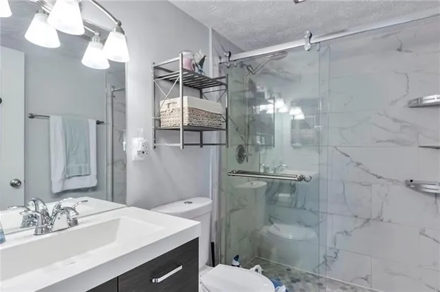 a bathroom with a sink toilet a mirror and shower