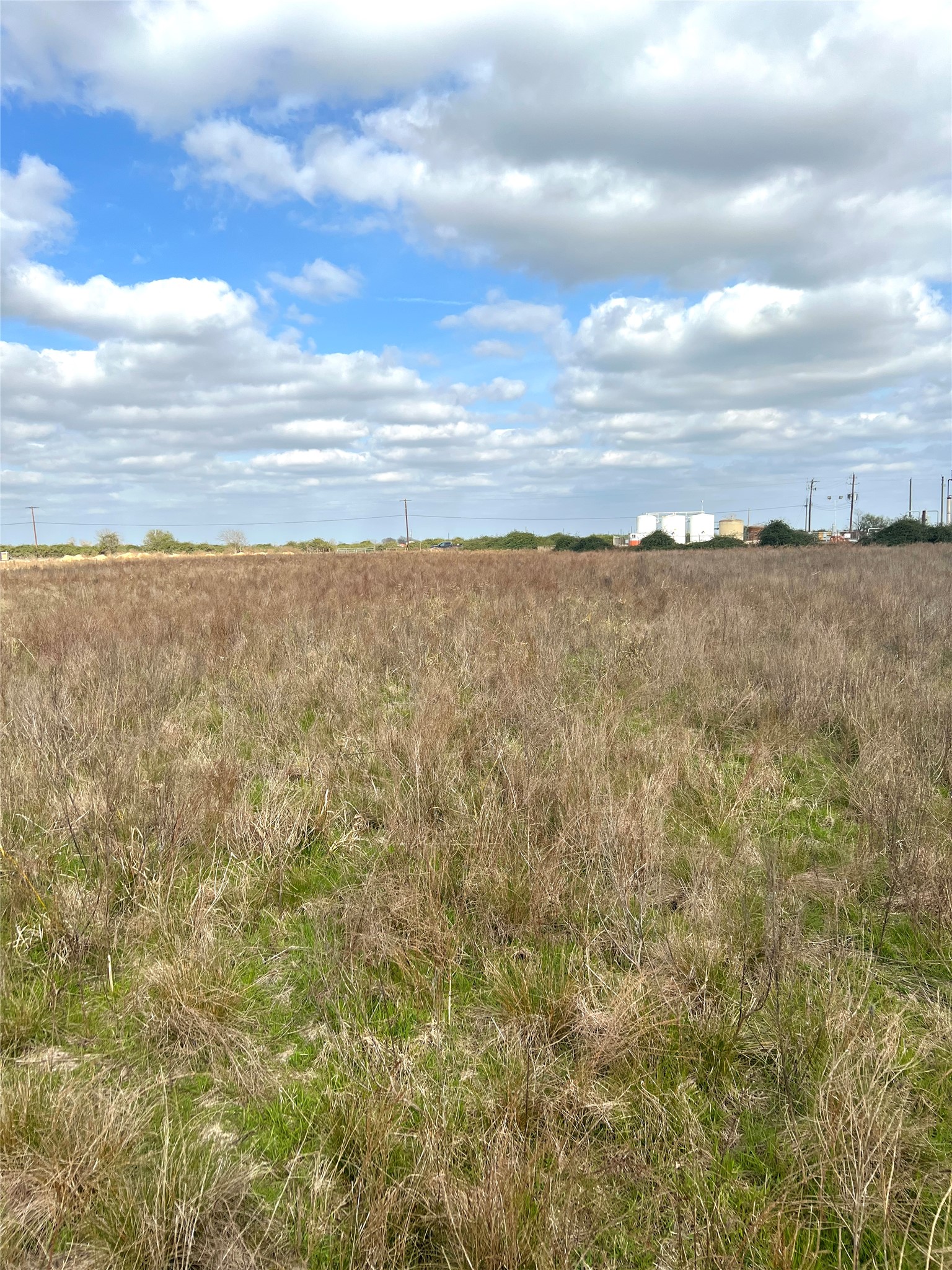 Tbd Lot 2 Tbd Road Eagle Lake, TX 77434 - Photo 24 of 24 Expansive open field with natural grass and a distant industrial backdrop