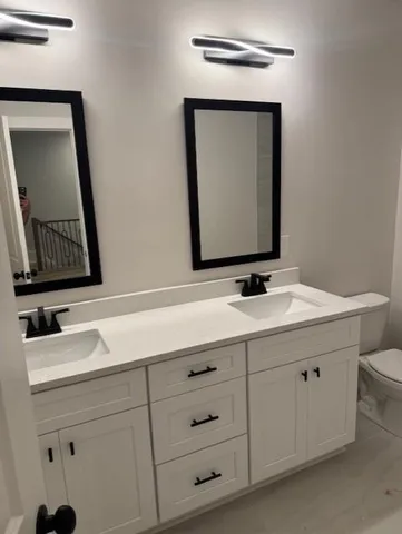 a bathroom with a double vanity sink and a mirror