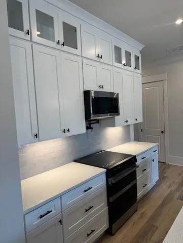a kitchen with stainless steel appliances a stove microwave and cabinets