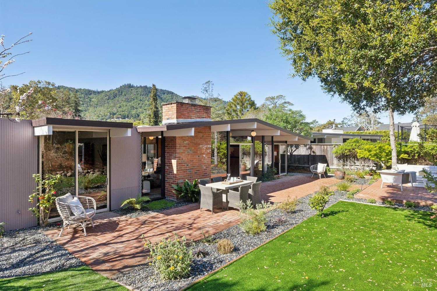1200 Idylberry Road San Rafael, CA 94903 - Photo 18 of 58 a view of a patio with table and chairs under an umbrella with large trees