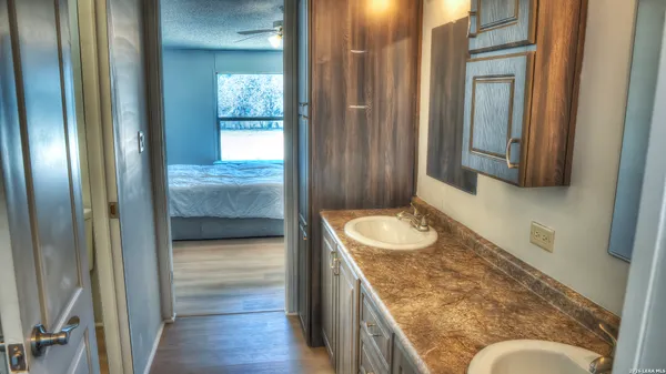 a en suite bathroom with a granite countertop sink and a mirror