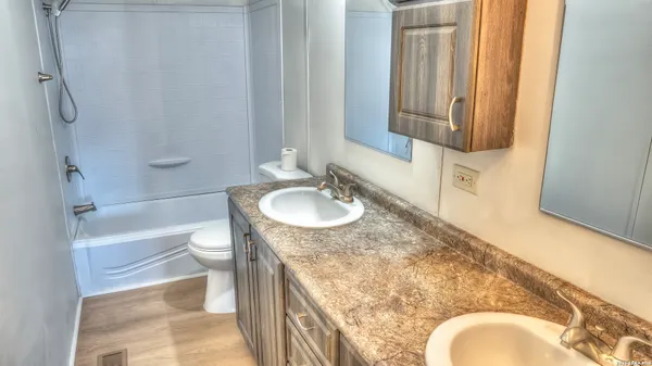 a bathroom with a granite countertop sink toilet and shower