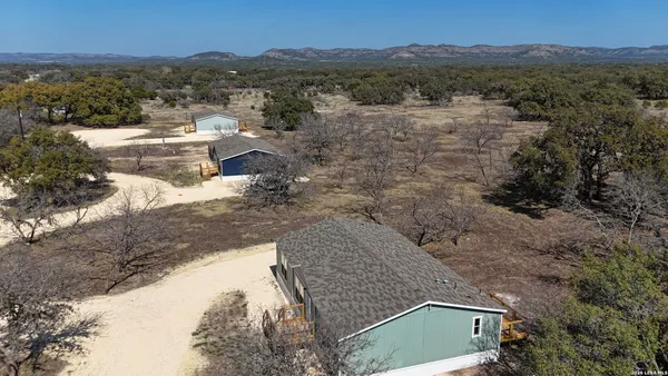 a view of a house with a mountain and yard