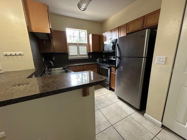 3031 Southwest Archer Road, Unit 2A Gainesville, FL 32608 - Photo 2 of 10 a kitchen with granite countertop a refrigerator a sink and a stove