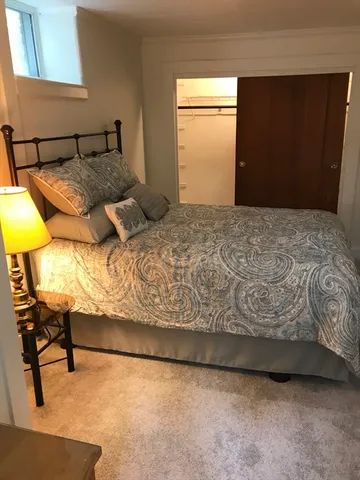 a bedroom with a bed and a chair in it