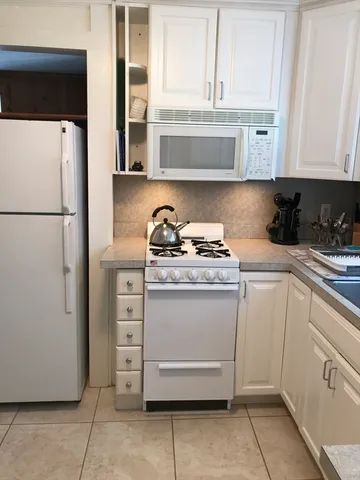 a kitchen with stainless steel appliances white cabinets and a refrigerator