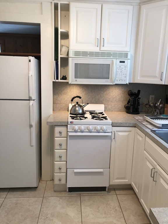 138 R Weston Road, Unit 138R Wellesley, MA 02482 - Photo 5 of 16 a kitchen with stainless steel appliances white cabinets and a refrigerator