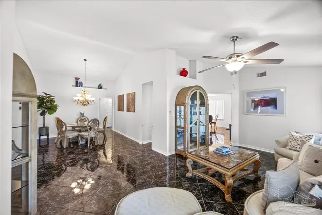 a living room with furniture a chandelier and a dining table
