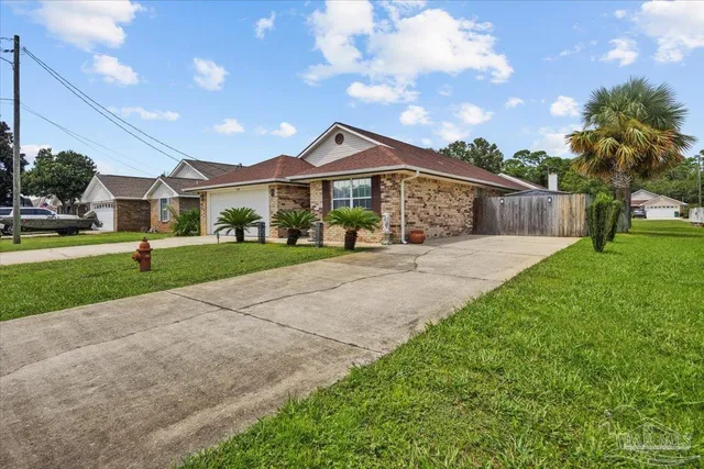 a front view of a house with a yard and potted plants