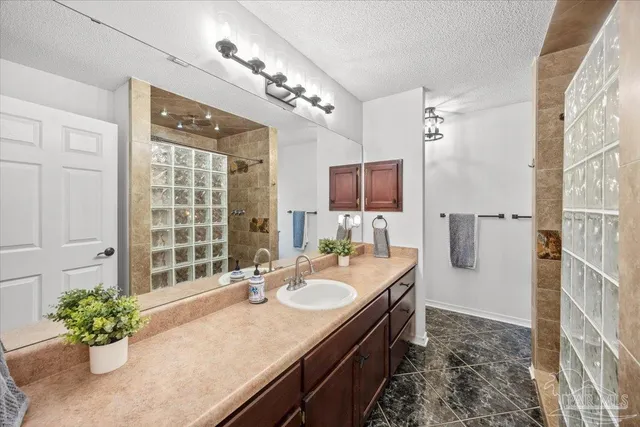 a bathroom with a granite countertop sink a large mirror and a shower