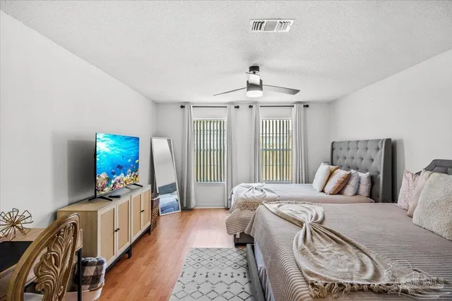 a bedroom with a bed a chandelier and dresser