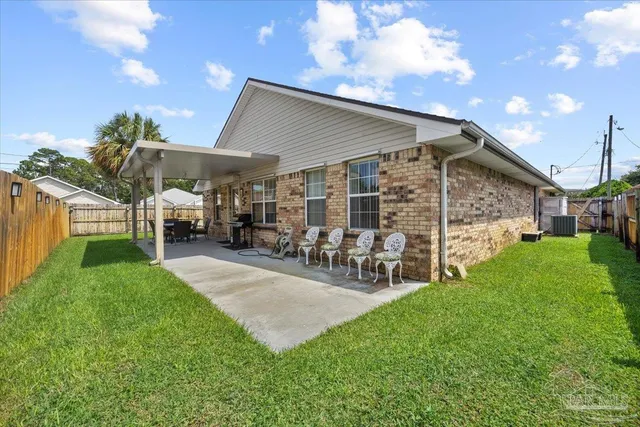 a view of a porch with chairs and a yard