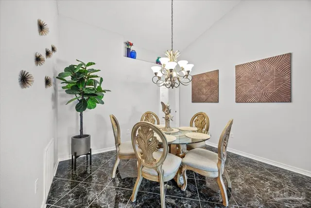a view of a dining room with furniture and chandelier