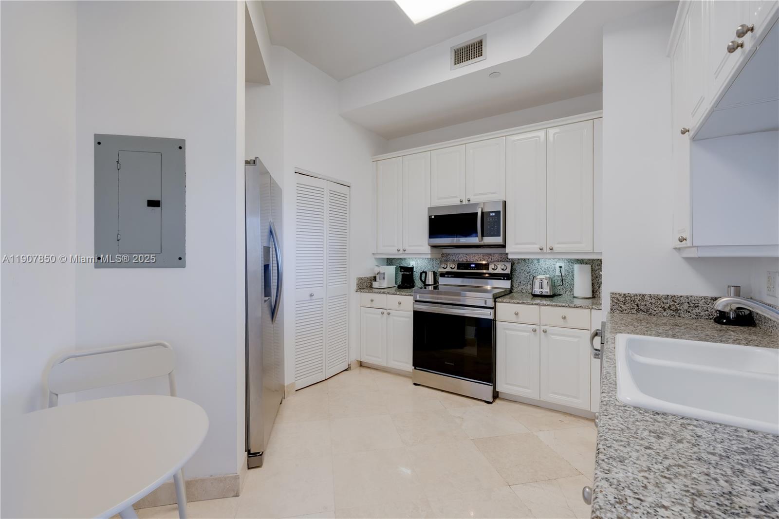 888 Brickell Key Drive, Unit 2610 Miami, FL 33131 - Photo 20 of 37 a kitchen with a sink a stove a microwave a refrigerator a dining table and chairs