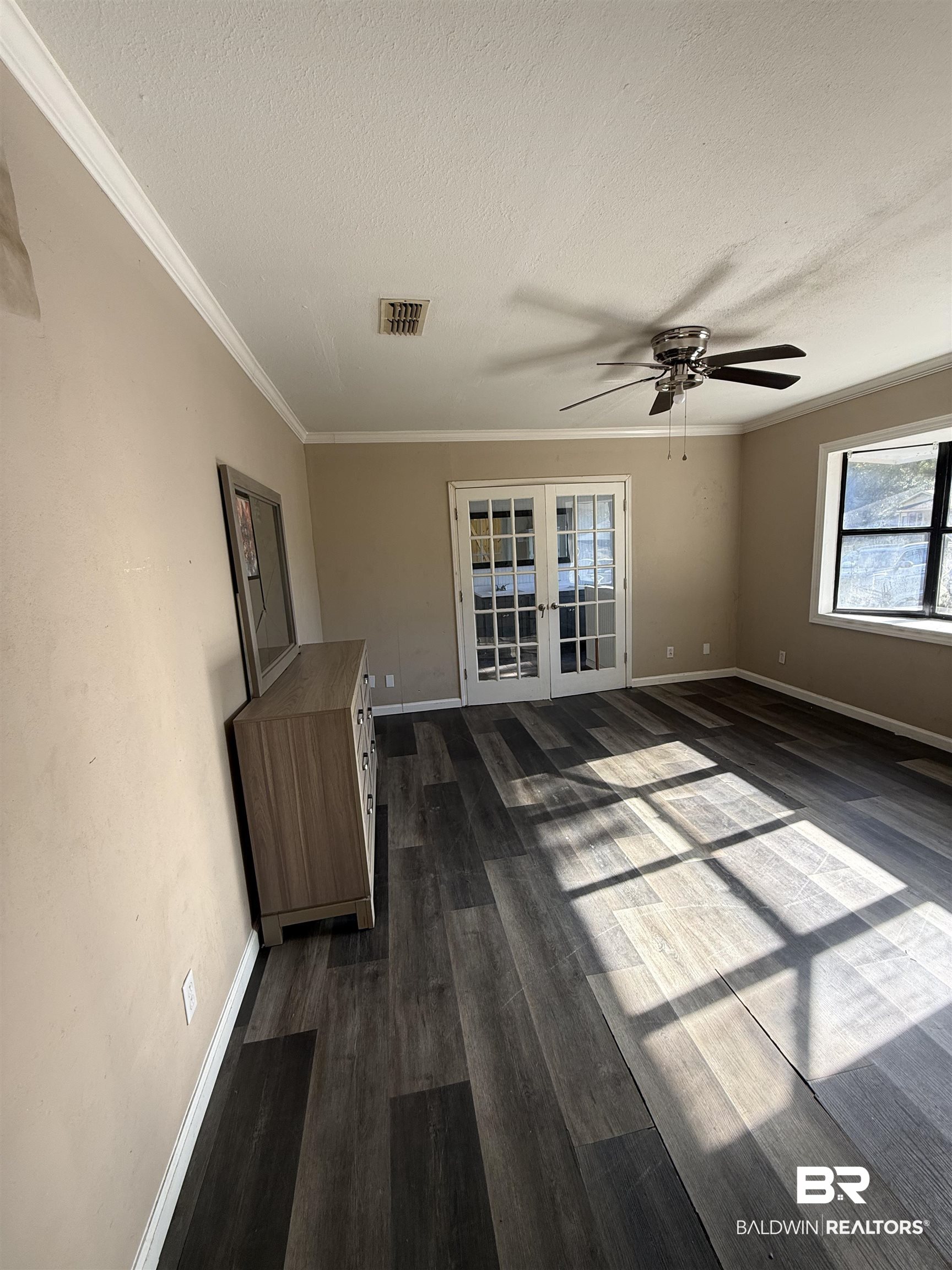 6745 Carol Plantation Road Theodore, AL 36582 - Photo 5 of 13 Unfurnished living room with dark wood-style flooring, crown molding, french doors, a textured ceiling, and ceiling fan