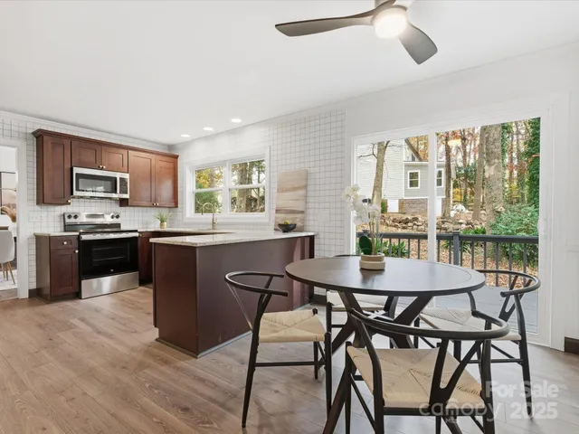 a kitchen with kitchen island a dining table and chairs