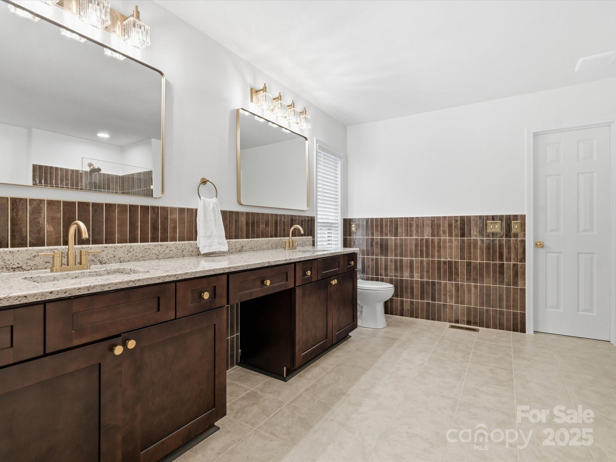 3909 Brownes Ferry Road Charlotte, NC 28269 - Photo 19 of 47 a bathroom with a double vanity sink a toilet and a mirror
