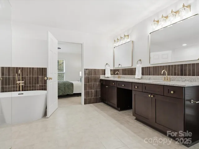 a large bathroom with a double vanity sink a mirror and a bathtub