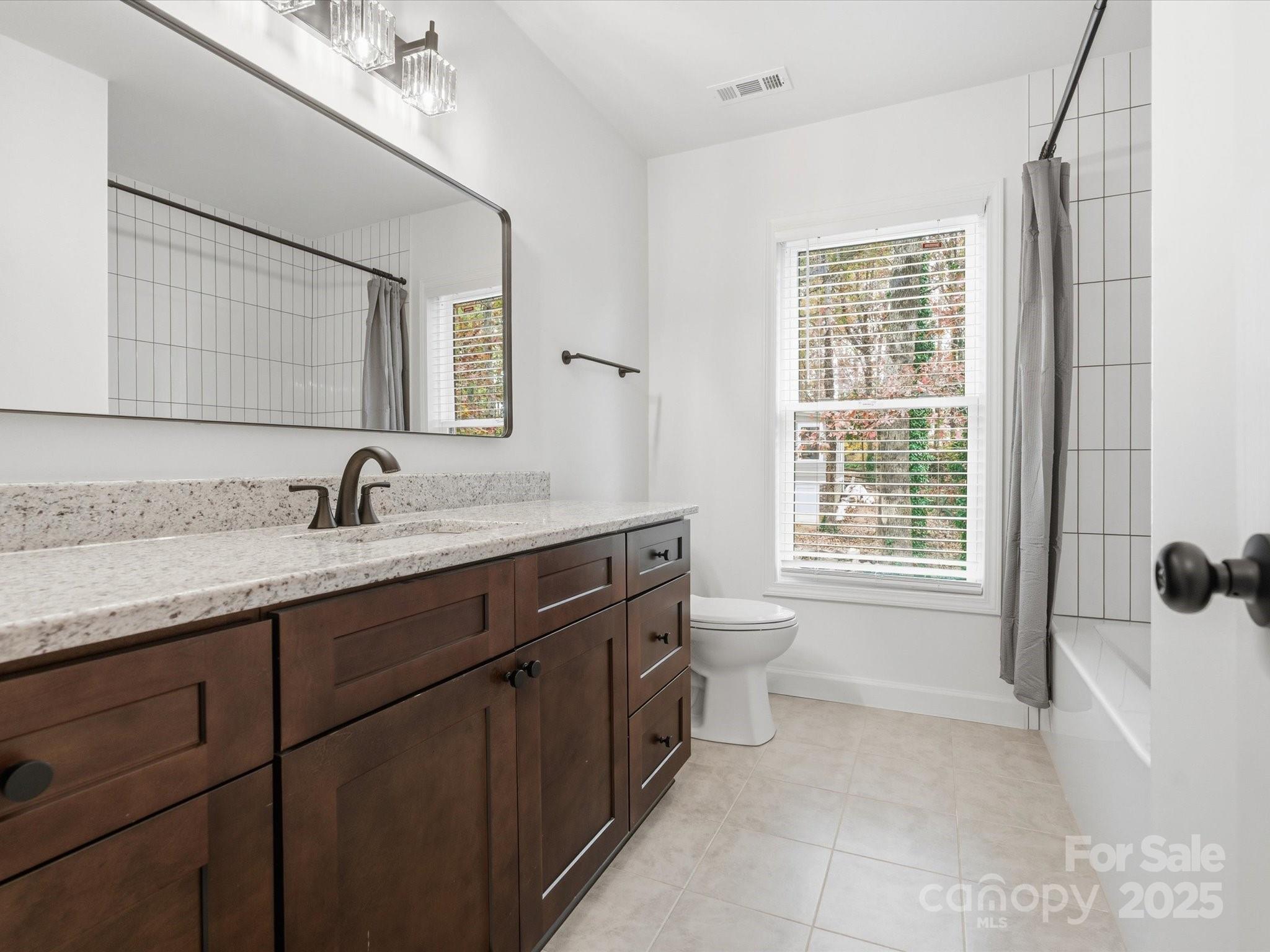 3909 Brownes Ferry Road Charlotte, NC 28269 - Photo 29 of 47 a spacious bathroom with a granite countertop sink a mirror a and a bathtub