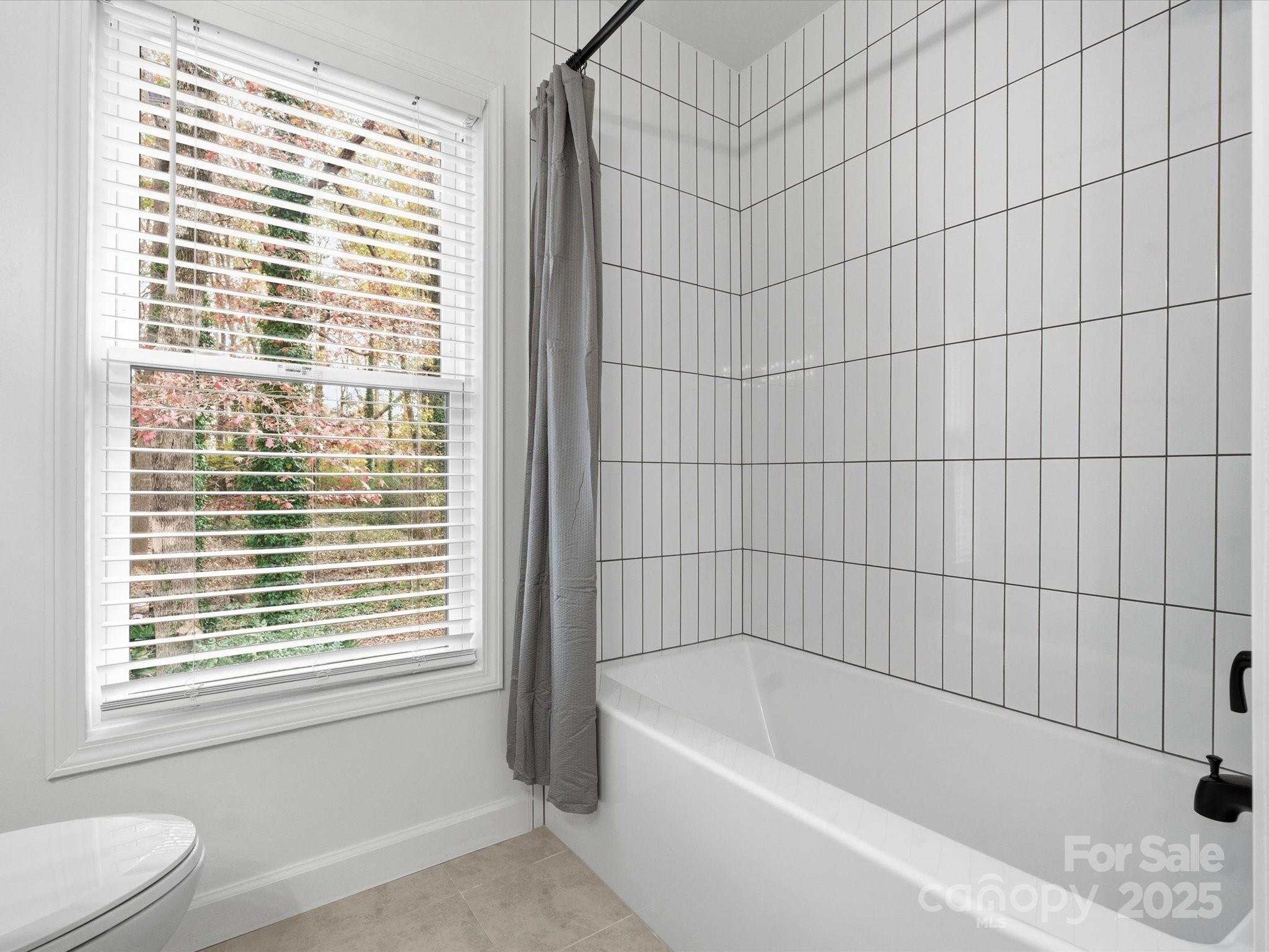 3909 Brownes Ferry Road Charlotte, NC 28269 - Photo 30 of 47 a bathroom with a bathtub and window