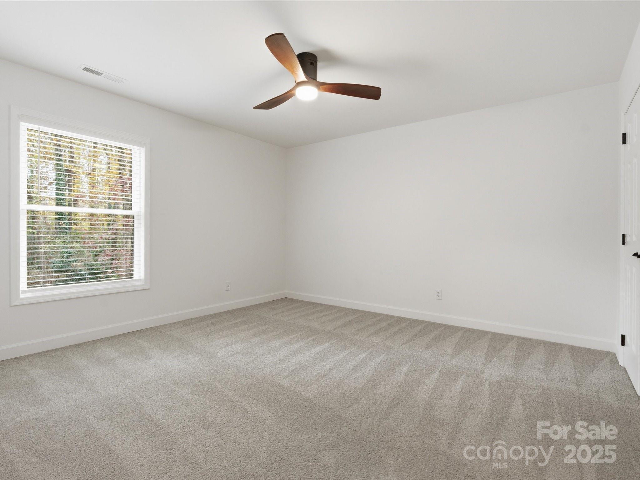 3909 Brownes Ferry Road Charlotte, NC 28269 - Photo 31 of 47 an empty room with a ceiling fan and window