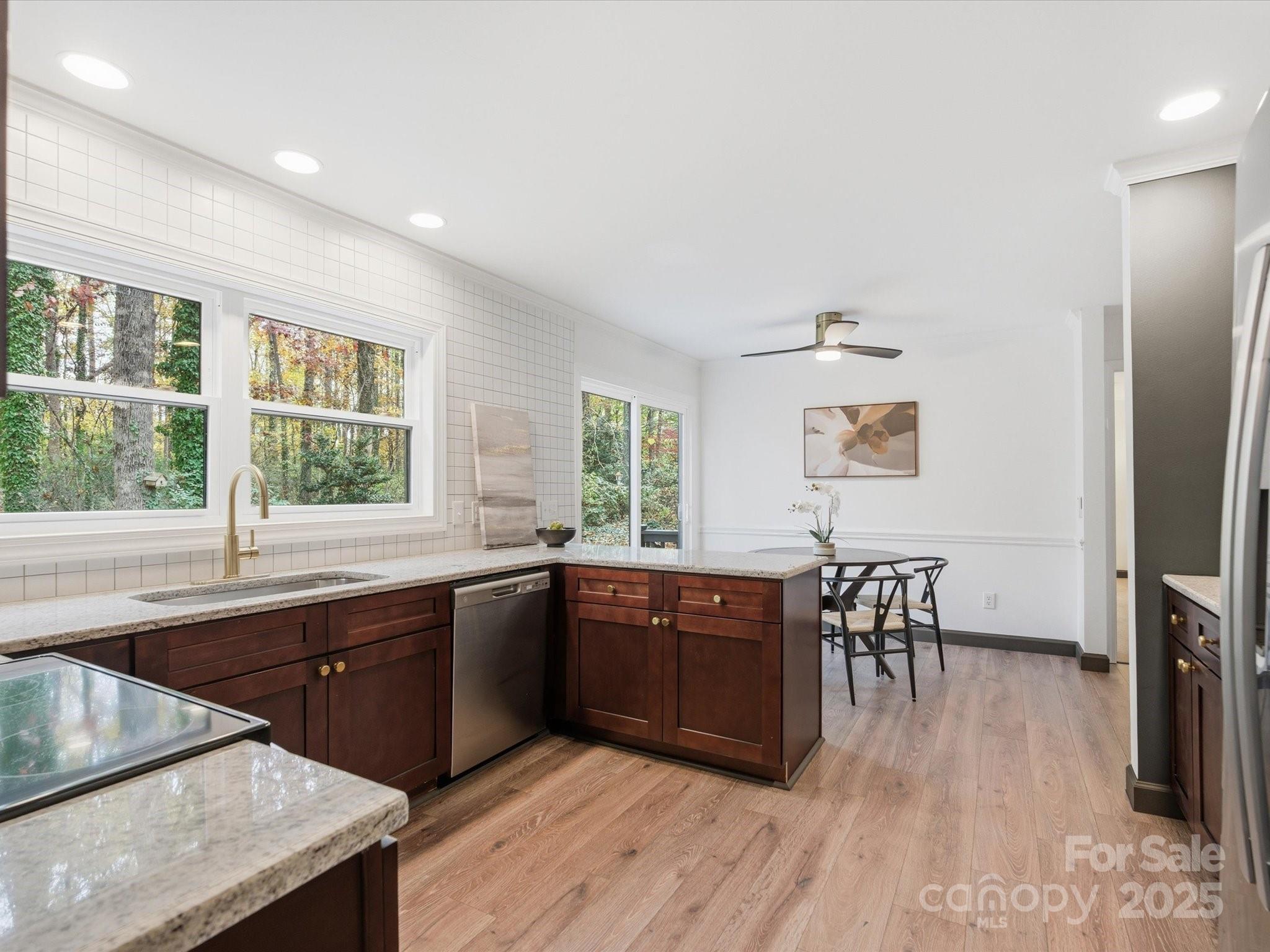 3909 Brownes Ferry Road Charlotte, NC 28269 - Photo 7 of 47 a large kitchen with wooden floor and stainless steel appliances