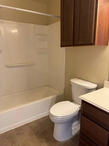 a white toilet sitting next to a bath tub